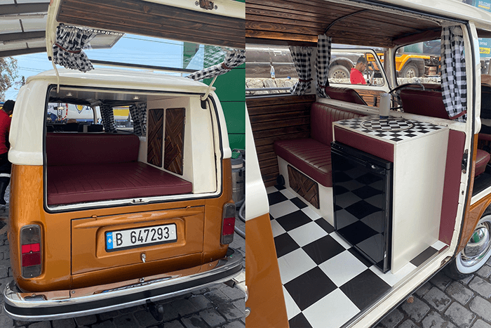 A lot of DIY work - @gero0oooo 12/2022 Interior and rear view of Gregory Kamel's (@gero0oooo) custom-restored vintage Volkswagen T2 camper van in Lebanon, featuring a foldable bed, checkered flooring, compact kitchen with mini fridge, red leather seating, wood paneling, and checkered curtains. Showcasing handcrafted DIY van conversion for off-grid vanlife travel.