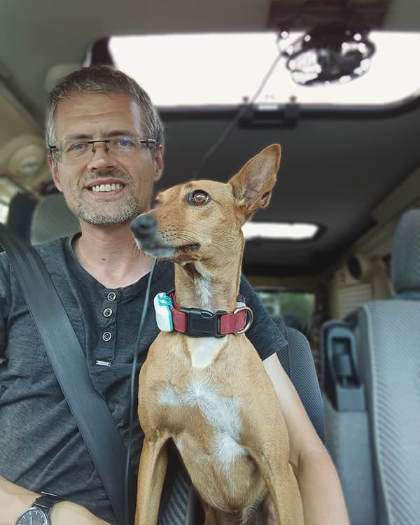 Danny & Boswell - @minimalistlandscapes 12/2024 Daniel (@minimalistlandscapes) sitting inside his camper van with his loyal companion Boswell, a small brown dog wearing a red collar, both looking content and ready for the next chapter in their vanlife journey.