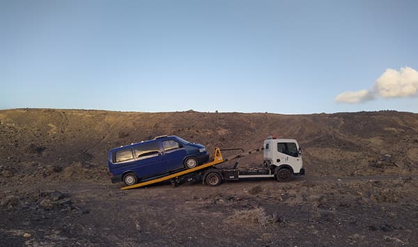"Quest" broke down on the Canary Islands - triptovantasia 06/2022 Jo and Georg’s blue VW T4 van from triptovantasia being towed in a remote desert landscape on the Canary Islands during their vanlife travels.